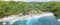 Magnificent aerial panorama of tropical beach at end of mountain valley with coconut palms, boats in blue water in Ocean gulf,