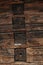 Magnificent background of a textured old wall made of brown wooden beams. Dark old rustic wooden background