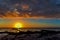 Magnificent evening landscape with a log near the sea and the sun at its zenith.