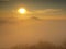 Magnificent heavy mist in landscape. Autumn fogy sunrise in a countryside. Hill increased from fog, the fog is colored to orange