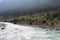 The magnificent Lidder river flowing through the valley in Pahalgam, surrounded by paddy fields