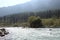 The magnificent Lidder river flowing through the valley in Pahalgam, surrounded by paddy fields