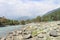 The magnificent Lidder river flowing through the valley in Pahalgam, surrounded by paddy fields