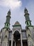 magnificent and luxurious mosque building. using green paint with a beautiful cloud background