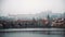 Magnificent panorama of old European town on foggy winter day. Amazing view on small buildings, still river with stone