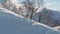 Magnificent panoramic shot of peaks covered in snow. Man with snowboard walking uphill to ride, backcountry style