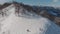 Magnificent panoramic shot of peaks covered in snow. Person with snowboard walking to unusual place to ride. Aerial view