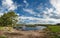 Magnificent panoramic spring-summer landscape with lonely fisherman, river and a beautiful cloudy sky.