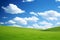 Magnificent panoramic view of vast green fields under a serene and captivating blue sky