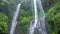 Magnificent shot from foot of waterfall in the rainforest, exuberant foliage of jungle and tons of water falling from a
