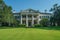 A magnificent, spacious white house featuring impressive columns and pillars, exuding elegance and grandeur, A Colonial Revival