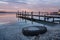 Magnificent sunset abandoned tire, wooden Pier on the lake. A tranquil sunset over a Varna lake