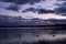 Magnificent sunset skies with dark menacing clouds above the lake reflecting sky with clouds and ducks gliding along the