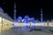 Magnificent view of the inner area of The Sheikh Zayed Grand Mosque, beautifully illuminated with blue light in the evening