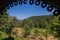 A magnificent view of the mountains under a blue cloudless sky from under the roof of a gazebo made in the form of an