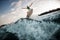 magnificent view of splashing wave and man skilfully jumping over it on wakeboard