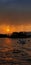 A magnificent view of sunset near lake side along with the combination of rain and mountain. A sunset view of a boat .