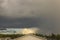 Magnificent view of thunder sky with rising sun over roofs of village houses.