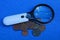 Magnifier and a bunch of old copper coins on a blue table