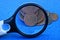 Magnifier and a bunch of old copper coins on a blue table