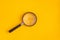 Magnifier lies on yellow and blue background. View from above. Flat lay. Copy space