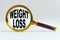 Magnifier on a white background  inside the text is written - WEIGHT LOSS