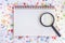 Magnifying glass on blank notebook with alphabet letter beads ba