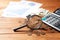 Magnifying glass, coins, calculator and statistics on the table