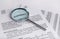 Magnifying glass and contract. Terms of agreement study. Investigation and business audit concept. Legal assessment of