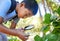 Magnifying glass, garden and an asian boy studying plants outdoor for education during a field trip. Kids, school and