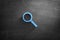 Magnifying glass icon on blackboard background