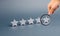 Magnifying glass is looking at five stars on a gray background. The concept of rating and evaluation. The rating of the hotel
