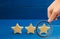 Magnifying glass is looking at the rating of the hotel, restaurant, mobile application. Three stars on a blue background. The conc