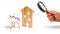 Magnifying glass is looking at the wooden house and red arrow down. concept of falling prices and demand for real estate, the fall