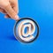 A magnifying glass looks at a email icon on blue background. internet correspondence. Contacts for business. Business tools