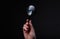 Magnifying glass or loupe in female hand on black background. Concept of searching in night, darkness