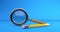 Magnifying glass with pencil lies on blueprint