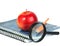 Magnifying glass, pencil and red apple