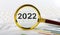 Magnifying glass with the word 2022 on the chart background