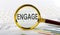 Magnifying glass with the word ENGAGE on the chart background