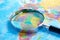 Magnifying glass with world glove map.