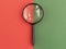 Magnifying lens over duotone green and red background. Search and research concept