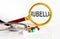 Magnifying lens with text RUBELLA with medical tools