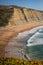 Magoito beach with surfers surfing on the sea waves in Sintra, Portugal