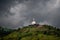 Mahamevnawa Buddhist Monastery temple in the mountain top low angle scenic landscape view. dark rainy clouds and cold atmosphere