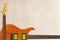 Mahogany electric guitar and neck on rough cardboard background, with plenty of copy space.