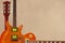 Mahogany and sunburst electric guitars and neck on rough cardboard background, with plenty of copy space.