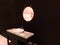 Mahogany wood and pebble stone cabinet with circular leather fabric mirror and mahogany wood wall. Modern luxury