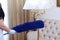 The maid dusts the floor lamp with a large brush. An unrecognizable photo . Concept of cleaning in a hotel or at home. Copy of the