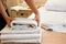 Maid placing fresh washed towels on a bed